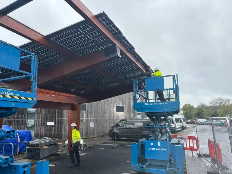 Commercial solar carport installation with cherry pickers